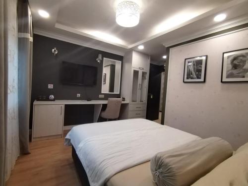 a bedroom with a bed and a desk with a computer at Grand Illusyin in Shah Alam