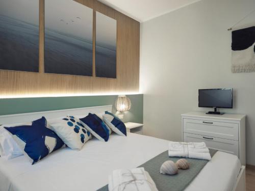 1 dormitorio con 1 cama con almohadas azules y blancas en La Dimora del Pescatore, en Vasto