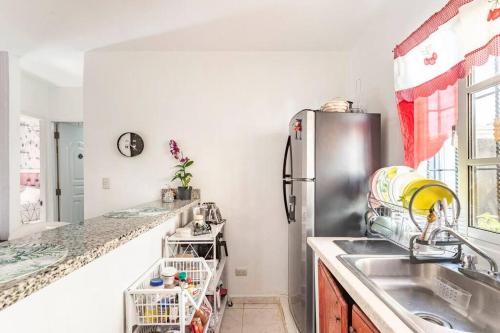 a kitchen with a sink and a refrigerator at Cozzy Flamingo in Concepción de La Vega