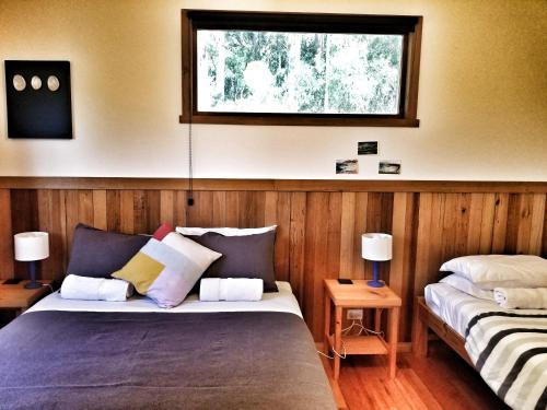 1 dormitorio con 2 camas y ventana en Southern Forest Accommodation, en Southport