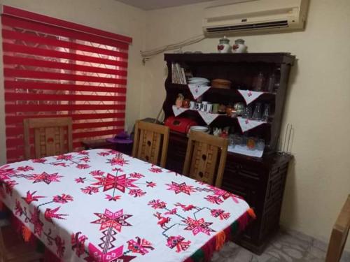 a bedroom with a bed with a red and white blanket at LOS TRES HUASTECOS in Ciudad Valles