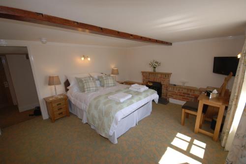 A bed or beds in a room at The Chequers Inn