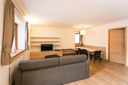 sala de estar con sofá y mesa en Mirtillo Blu Family Apartment, en Alagna Valsesia