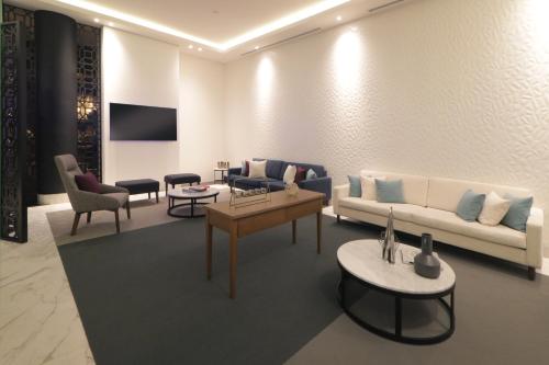 a living room with a couch and tables and chairs at Culiacan Marriott Hotel in Culiacán