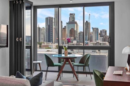 a living room with a table and chairs and a large window at Fortitude Valley Prime position 2 x Bed, view, parking, pool in Brisbane