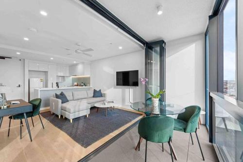 a living room with a couch and a table and chairs at Fortitude Valley Prime position 2 x Bed, view, parking, pool in Brisbane