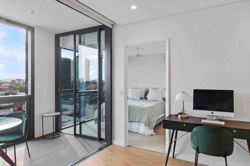 a bedroom with a bed and a desk with a computer at Fortitude Valley Prime position 2 x Bed, view, parking, pool in Brisbane