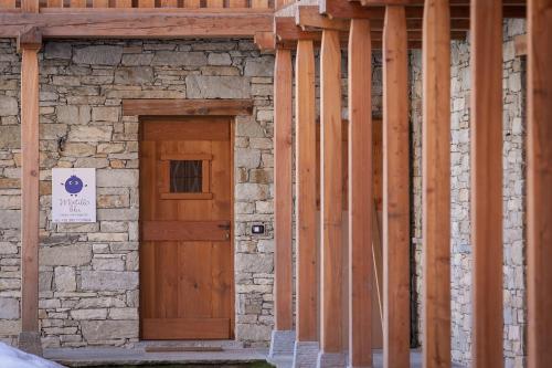 a building under construction with a wooden door at Mirtillo Blu Family Apartment in Alagna Valsesia