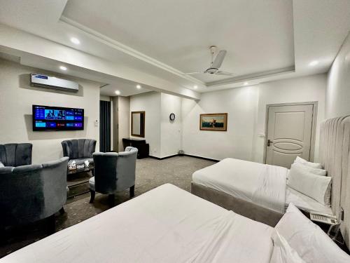 a hotel room with two beds and a flat screen tv at MUDAN hotel and suite in Islamabad