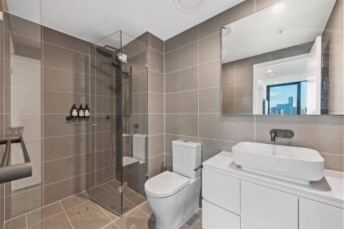 uma casa de banho com um WC, um lavatório e um espelho. em Prime Located Luxe 2 BR Sky Home/Sensational Views em Brisbane