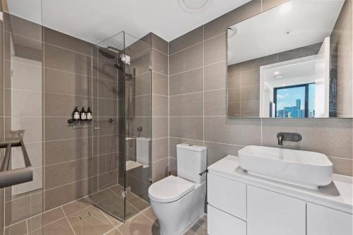 a bathroom with a toilet and a sink and a mirror at Prime Located Luxe 2 BR Sky Home/Sensational Views in Brisbane