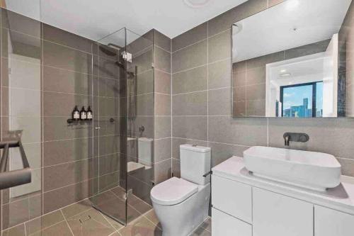 New 3 Bed Penthouse Resort style complex في بريزبين: حمام مع مرحاض ومغسلة ودش