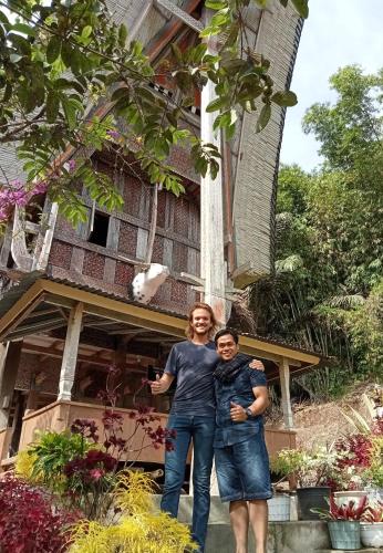 a man and woman standing in front of a house at NUANSA HOMESTAY Authentic&Hospitality in Rantepao