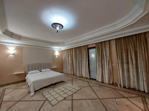 Habitación grande con cama y lámpara de araña. en Villa Dahlia, en Marrakech