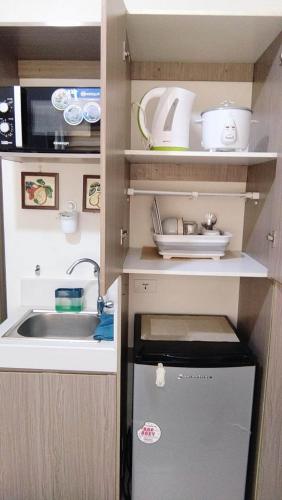 a small kitchen with a sink and a microwave at JJMC HOMESTAY 22 With netflix and fast wifi in Manila