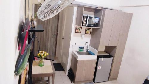 uma pequena cozinha com um lavatório e um frigorífico em JJMC PLACE 22f em Manila