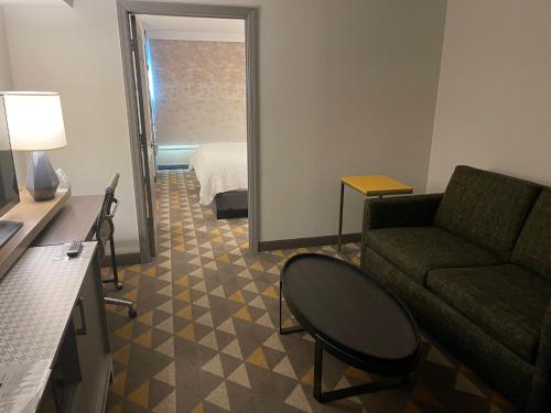 a living room with a couch and a room with a bed at Holiday Inn Martinsburg by IHG in Martinsburg
