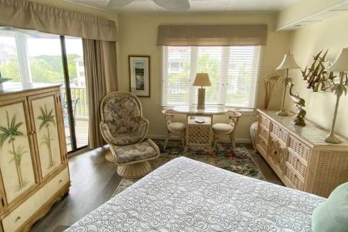 1 dormitorio con 1 cama, 1 mesa y 1 silla en Port O' Call C302 - IOP Island Retreat! Treetop Oceanview!, en Isle of Palms