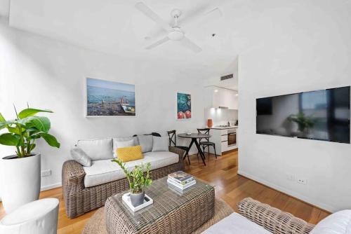 a living room with a couch and a tv at Newstead Ideally Located 2bed 2Bath Free Parking in Heart of Everything in Brisbane