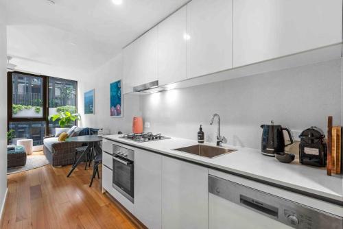 a white kitchen with a sink and a stove at Newstead Ideally Located 2bed 2Bath Free Parking in Heart of Everything in Brisbane