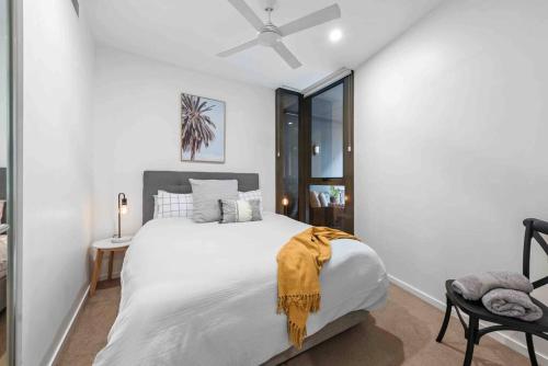 a bedroom with a large white bed with a ceiling fan at Newstead Ideally Located 2bed 2Bath Free Parking in Heart of Everything in Brisbane
