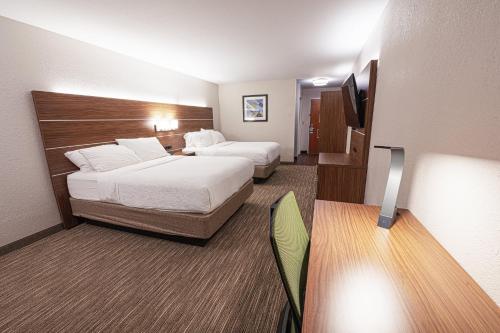 a hotel room with two beds and a television at Holiday Inn Express Hotel & Suites East Lansing, an IHG Hotel in East Lansing