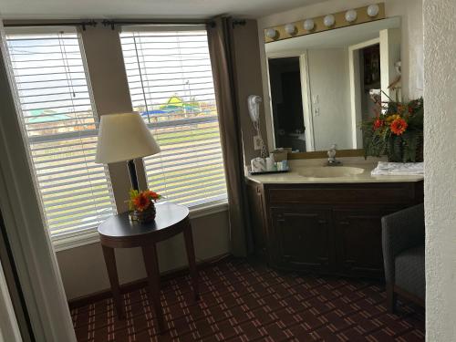 a bathroom with a sink and a table with a lamp at Branson Victorian Inn in Branson