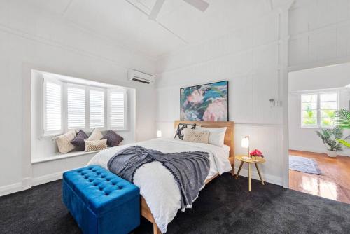 a bedroom with a large bed and a blue couch at Charming 5BR Family Home w/Pool 10min from Airport in Brisbane