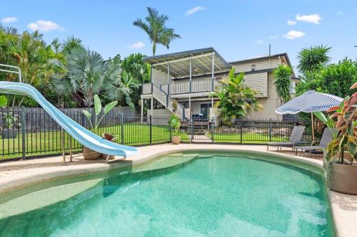 einem Pool mit Rutsche vor einem Haus in der Unterkunft Charming 5BR Family Home w/Pool 10min from Airport in Brisbane