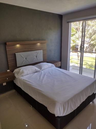 1 dormitorio con 1 cama grande y ventana grande en Casas Real Imperio Blue, en Xochitepec