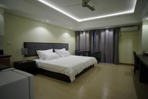 a bedroom with a large bed and a desk at Luxe in Venice in Manila