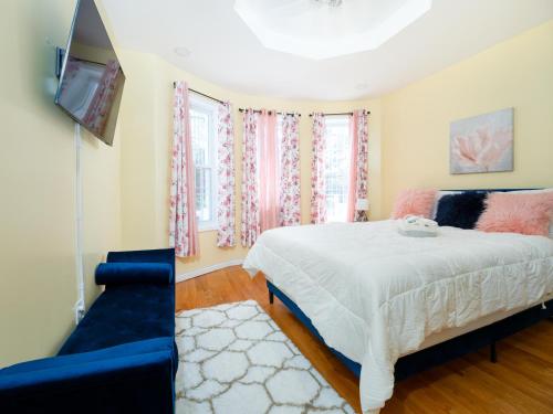 um quarto com uma cama, uma televisão e um sofá em A slice of paradise awaits you! em Brooklyn