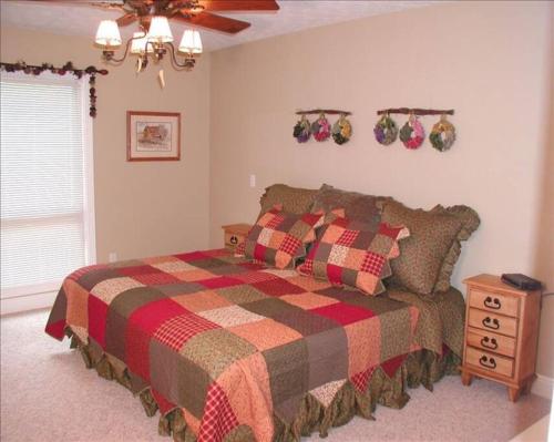 ein Schlafzimmer mit einem Bett mit einer karierten Decke in der Unterkunft Lake Cumberland's Woodson Bend Resort Condominium in Burnside
