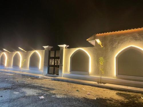 a building with a row of arches at night at استراحة الضيافة in Al Jubail