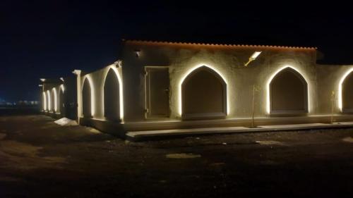 a building with lights on it at night at استراحة الضيافة in Al Jubail