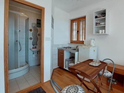- une cuisine avec une table, un évier et une douche dans l'établissement Apartments Dara, à Crikvenica