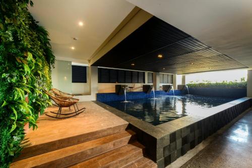 a house with a swimming pool in the middle at Nata Azana Hotel Solo in Solo
