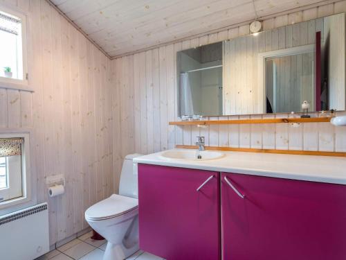 a bathroom with a purple vanity and a toilet at Holiday Home with Spa & Sauna in Oksbøl