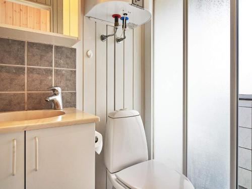 a small bathroom with a toilet and a sink at Holiday home Aakirkeby II in Vester Sømarken