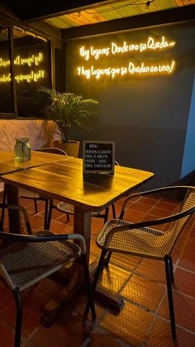 a wooden table with two chairs and a laptop on it at Hotel Neblina Calima in Calima