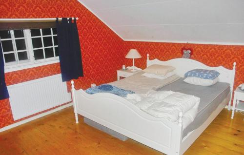 a bedroom with a white bed in a red wall at Amazing Home In Rottneros With Kitchen in Bråsstorp
