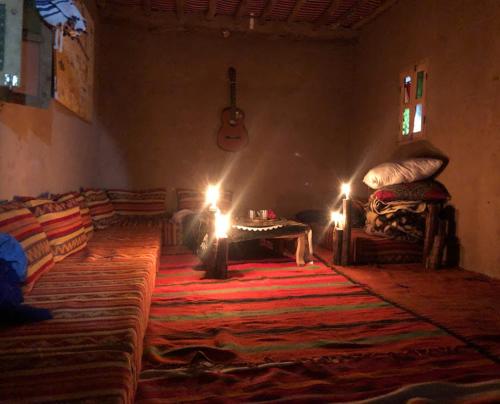 a living room with a rug and a table with lights at Desert skay camp in Mhamid