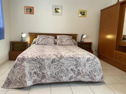 sypialnia z łóżkiem z szarą i białą kołdrą w obiekcie Charmante Maison avec Jardin et Parking Privé, à 4 km de la Plage - Idéalement Située à Erdeven - FR-1-397-70 w mieście Erdeven