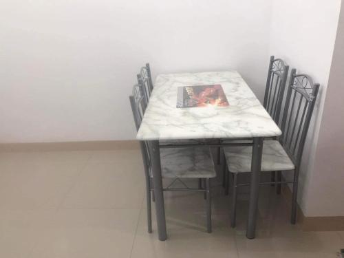 uma mesa de jantar com cadeiras e uma mesa de mármore branco e cadeira em Watanabe Condo Unit em Pasong Bayog
