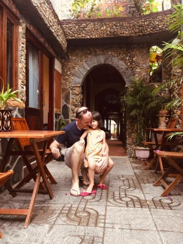 a man holding a statue of a little girl at Sầm Sơn Boutique Hotel Phan Thiết in Phan Thiet
