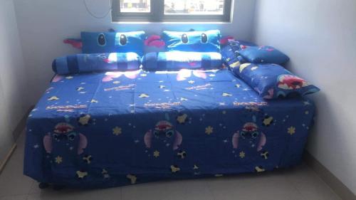 um quarto com uma cama com um edredão azul em Watanabe Condo Unit em Pasong Bayog