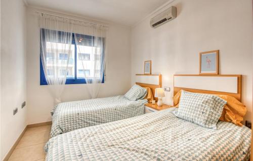 1 dormitorio con 2 camas y ventana en Stunning Apartment In Alicante With Outdoor Swimming Pool, en Alicante