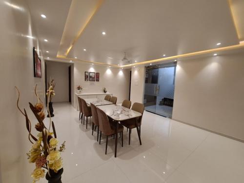 a dining room with a table and chairs at Bouquet Residency in Nashik