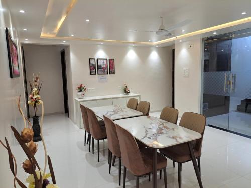 a dining room with two tables and chairs and a counter at Bouquet Residency in Nashik
