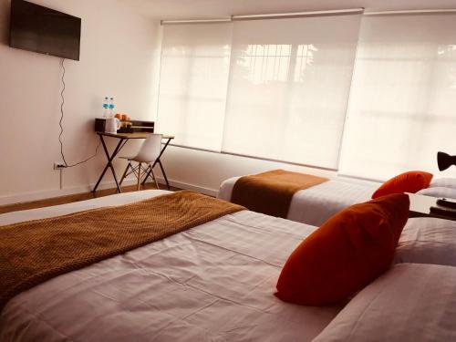 a hotel room with two beds and a window at CASA CREAZZO 62 - Movistar Arena in Bogotá